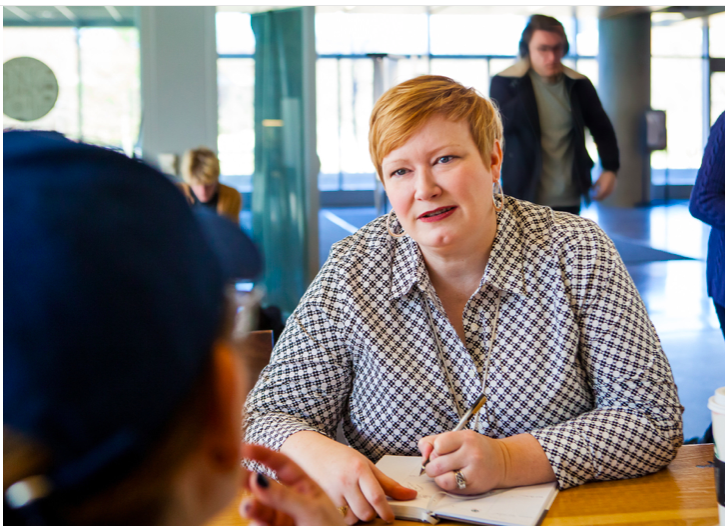 Picture of Kat taking notes while listening to a client